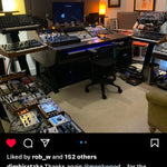 A social media post showing a home studio setup with a large mixing console, multiple synthesizers, a computer monitor, and audio equipment in a room with warm ambient lighting.
