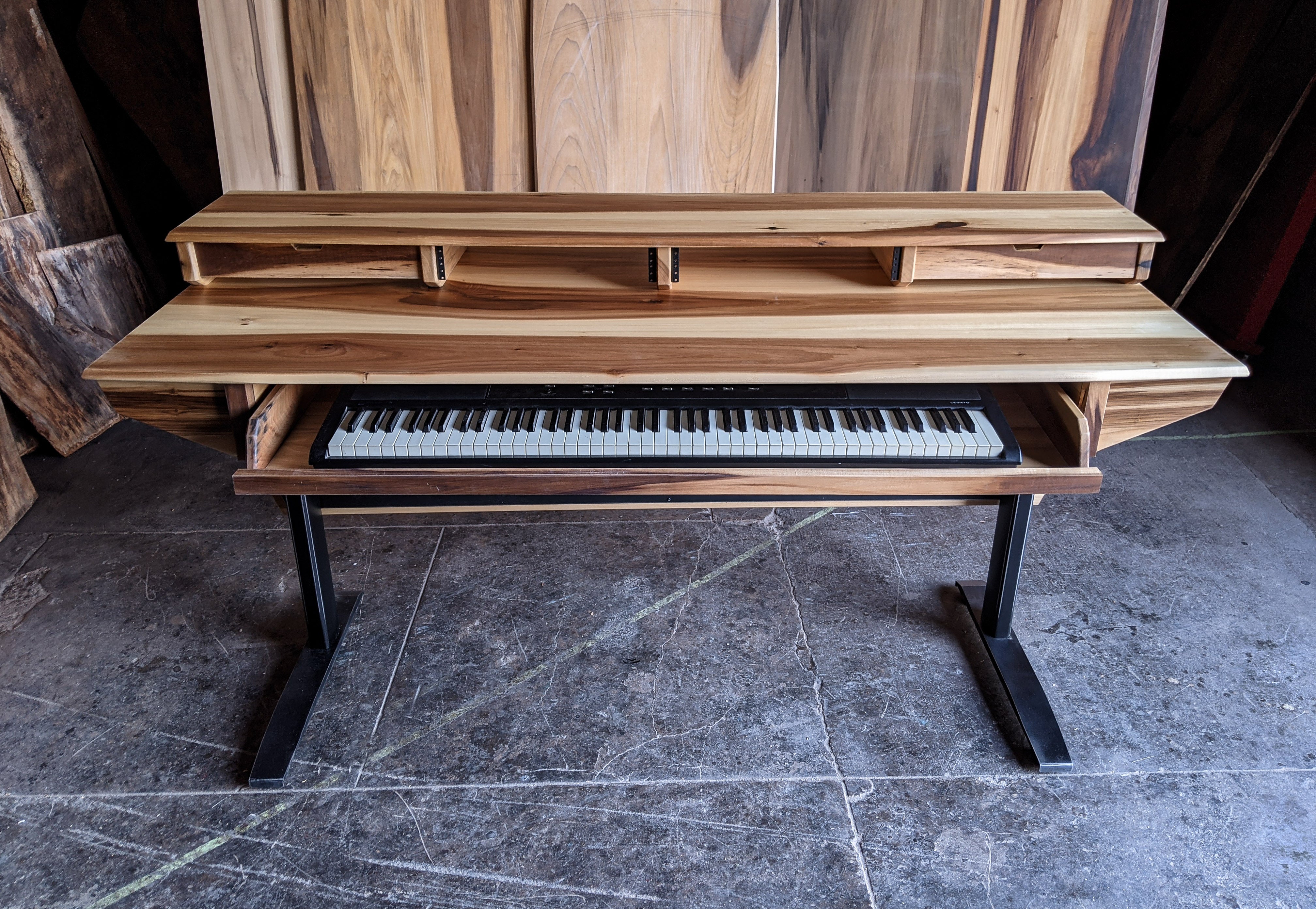 Wooden digital piano  studio deskon a gray floor with wooden wall in the background
